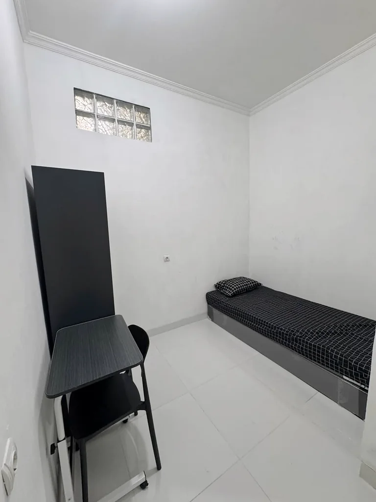 Kamar tidur single dengan meja kerja dan jendela glass block
