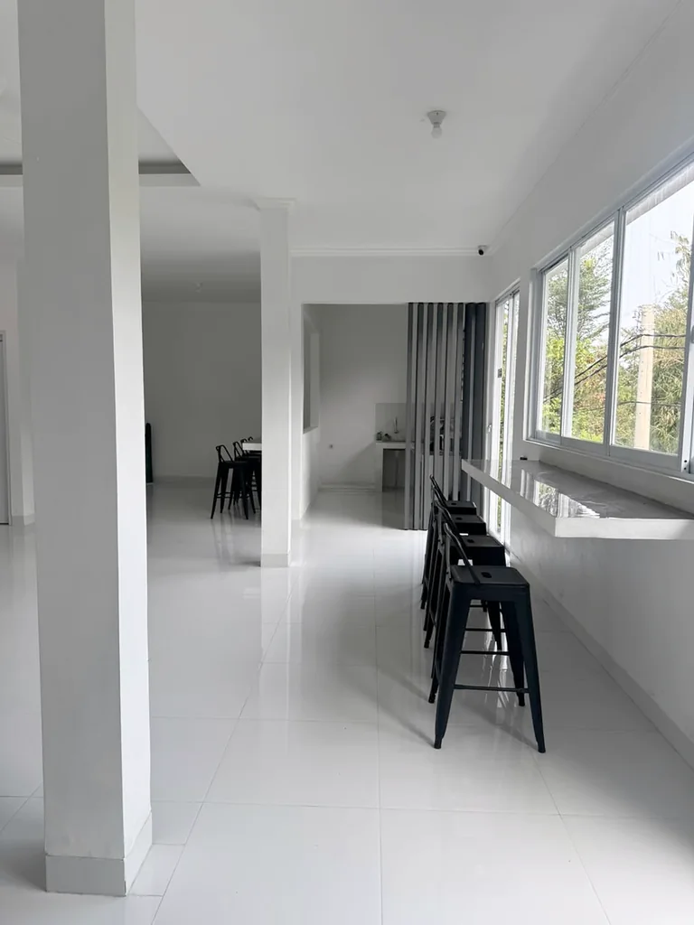 Area minibar dengan meja panjang di samping jendela dan kursi tinggi